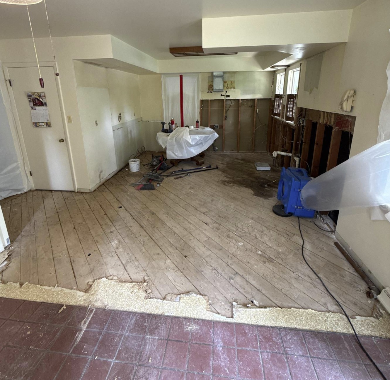 Water damaged kitchen with subfloor exposed and drying equipment running during restoration in North Royalton, OH